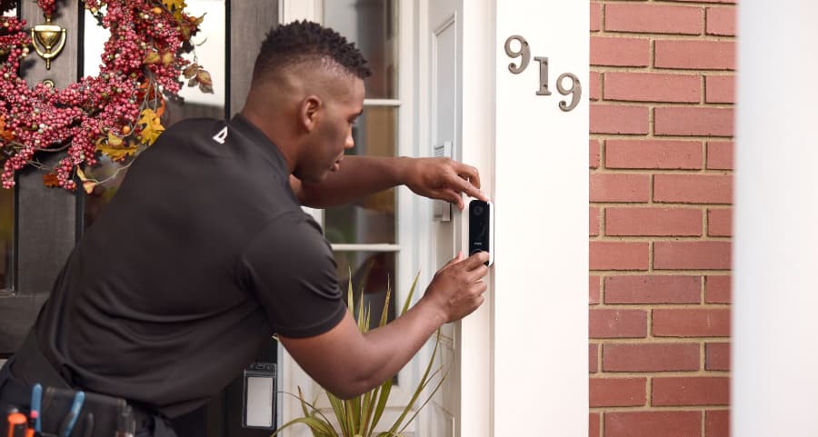 Vivint technician installing a doorbell camera on the exterior of a home